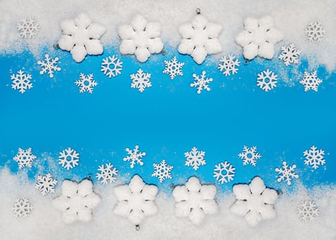 Christmas background. White decorations Christmas balls and snowflakes on soft snow, copy space, place for text photo