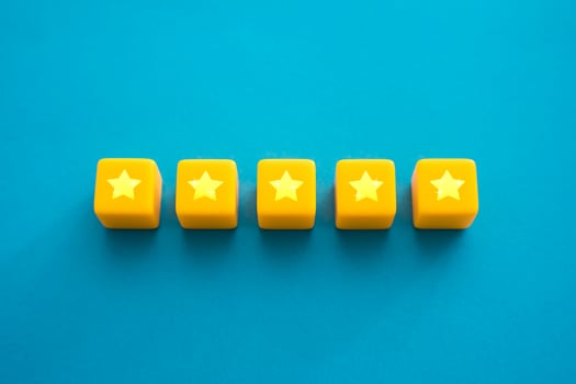 Five stars in a row on yellow blocks. Evaluation of the quality of the provided service. Feedback overview. Popularity, prestige. High reputation. Successful business, satisfied customers. photo