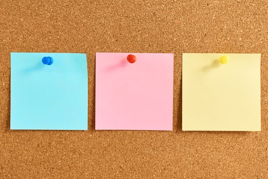 Cork board with a pinned colored blank notes photo