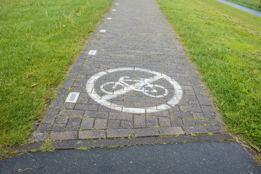 Stone footpath with a sign painted on it forbidding cycling. Security concept. photo