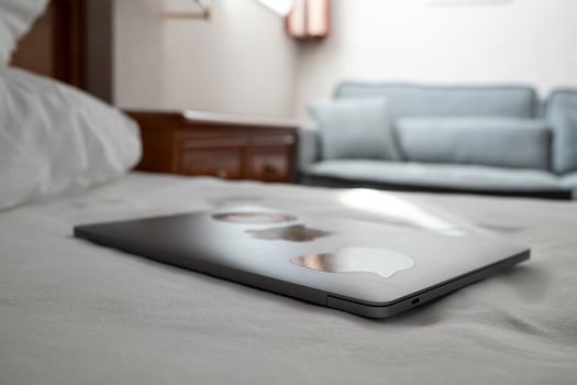 Closed laptop on the bed, in a hotel room. Remote work with ultrabook. photo