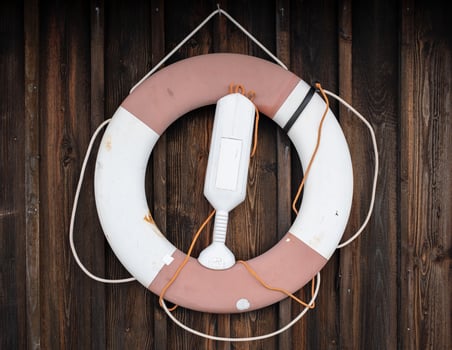 Lifebuoy hangs on the wooden wall of the hut. Safe holiday concept. Close-up. photo