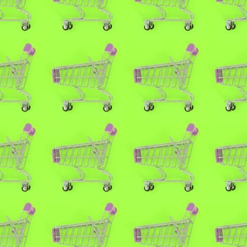 Shopping addiction, shopping lover or shopaholic concept. Many small empty shopping carts perform a pattern on a pastel colored paper background. Flat lay composition, top view photo