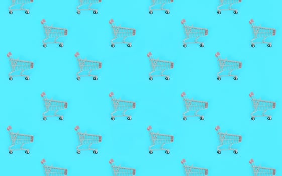 Shopping addiction, shopping lover or shopaholic concept. Many small empty shopping carts perform a pattern on a pastel colored paper background. Flat lay composition, top view photo