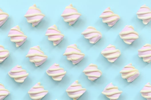 Colorful marshmallow laid out on blue paper background. pastel creative textured pattern. minimal photo