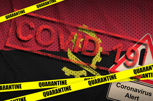 Angola flag and Covid-19 quarantine yellow tape with red stamp. Coronavirus or 2019-nCov virus photo