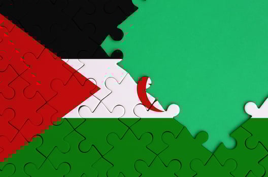 Western Sahara flag is depicted on a completed jigsaw puzzle with free green copy space on the right side photo