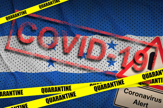 Honduras flag and Covid-19 quarantine yellow tape with red stamp. Coronavirus or 2019-nCov virus photo