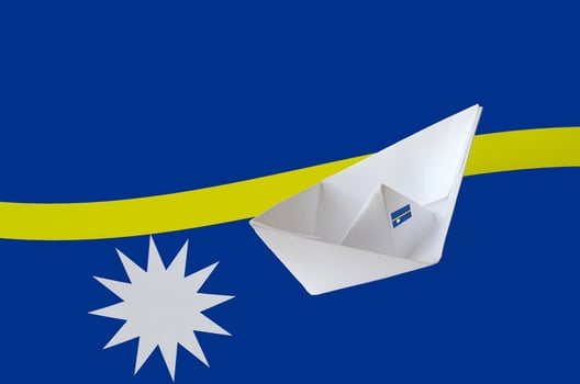 Nauru flag depicted on paper origami ship closeup. Handmade arts concept photo