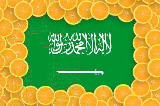 Saudi Arabia flag in fresh citrus fruit slices frame photo