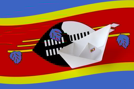 Swaziland flag depicted on paper origami ship closeup. Handmade arts concept photo