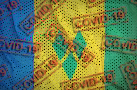 Saint Vincent and the Grenadines flag and many red Covid-19 stamps. Coronavirus or 2019-nCov virus concept photo