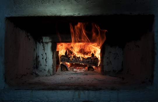 Retro Russian stove in which firewood burns in a village house. Kindling the oven for cooking. Traditional cuisine. photo