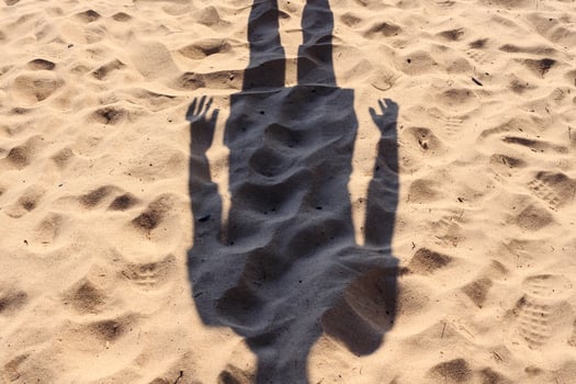 Headless human shadow on a sandy beach, on a sunny summer day. photo