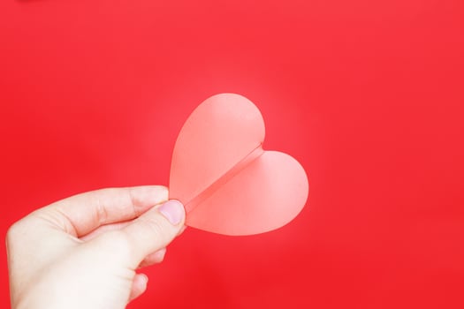 female hands hold a red heart isolated on a red background. Love, Wedding, Valentines day, 8 March concept. photo