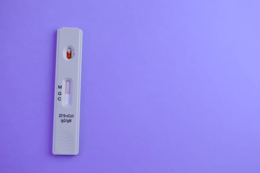 test for coronavirus lies on a purple background. a drop of venous blood on the test strip. medical laboratory, express diagnostics of coronavirus photo