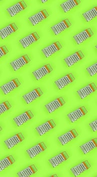 Small stainless steel graters lies on a pastel colored paper. Kitchen accessories. Tools for cooking. Flat lay top view photo