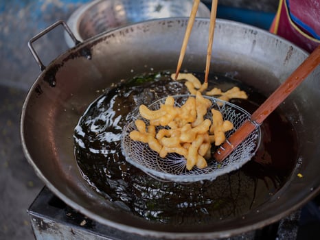 Die cut of Deep fried Chinese Doughnut in an big oil pan photo