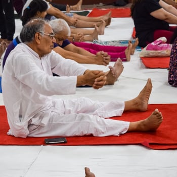 New Delhi, India, June 19 2022 -Group Yoga exercise session for people of different age groups in Balaji Temple, Vivek Vihar, International Yoga Day, Big group of adults attending yoga class in temple photo