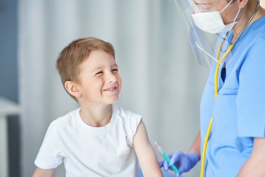 Portrait of adorable little boy being vaccinate at doctor's office photo