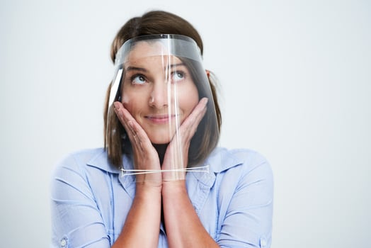 Attractive woman wearing protective shield thinking over white background photo