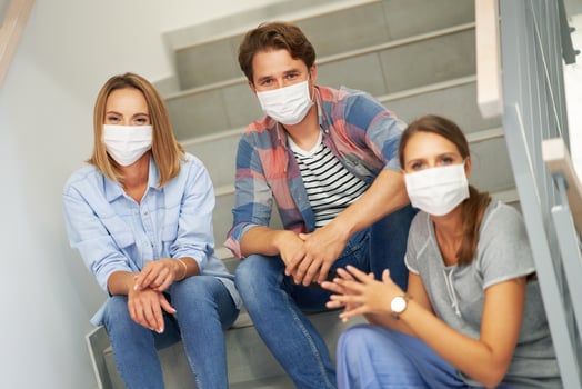 Couple of students wearing masks relaxing in the campus photo
