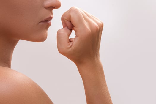 Closeup of a female mouth biting her fingers photo