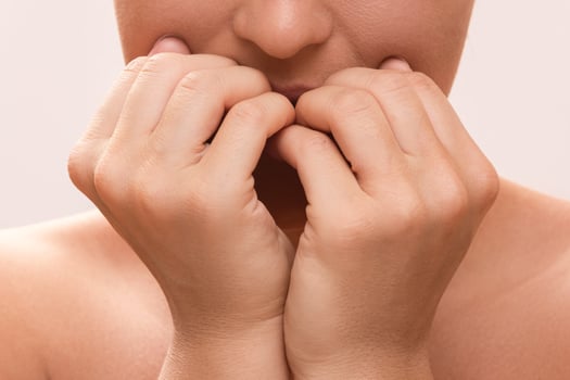 Closeup of a female mouth biting her fingers photo