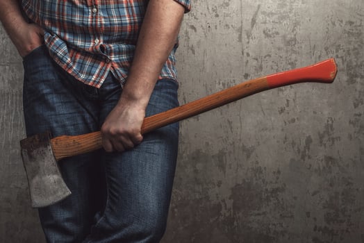 Axe in male hand over old dirty wall photo