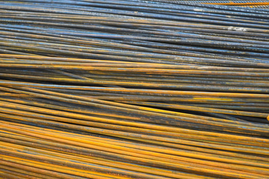 Iron metal rusty yellow bars of industrial building reinforcement from corrugated reinforcement for the construction of buildings made of reinforced concrete. Texture, background photo