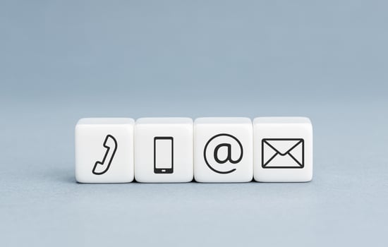 Contact us icons on white cube blocks on blue background. Copy space photo