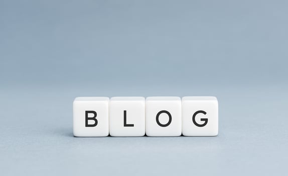 BLOG word on white cube blocks on blue background. Copy space photo