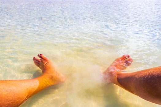Feet in clear turquoise water on Holbox island Mexico. photo