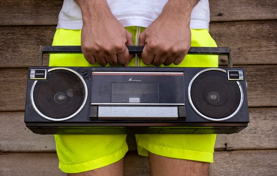 Man wearing yellow pants holding an old radio photo