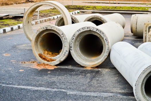 Large concrete stone cement sewer plumbing pipes of large diameter for the industrial construction of water supply or sewage at a construction site during the repair photo