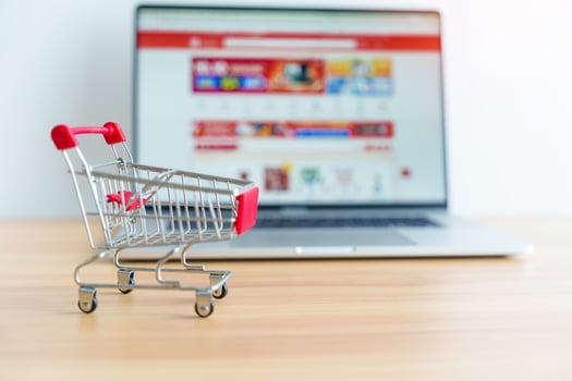 Shopping cart and laptop computer with marketplace website. business, technology, ecommerce, digital banking and online payment concept photo