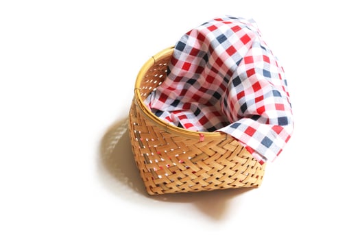 Bamboo basket with cloth on white background. Top view. photo