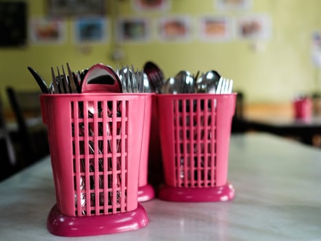 Cutlery in a pink plastic container photo