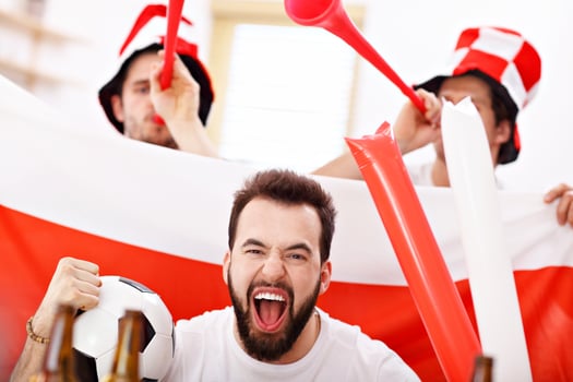 Happy male friends cheering and watching sports on tv photo