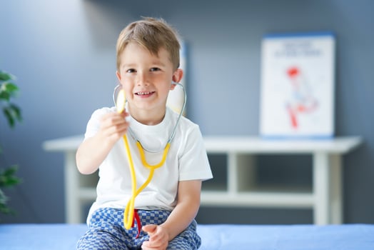 A little doctor with stethoscope smiling in doctor's office photo