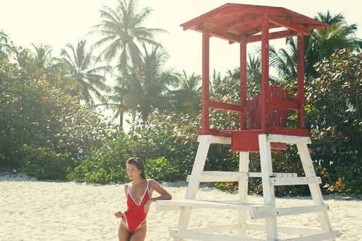 Sexy woman in red swimsuit beside lifeguard tower photo