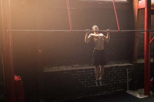 Strong man doing pull up exercise in the gym photo