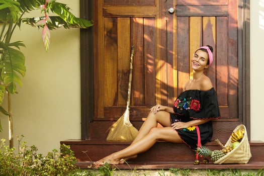 Beautiful woman sitting on the doorstep beside her house photo