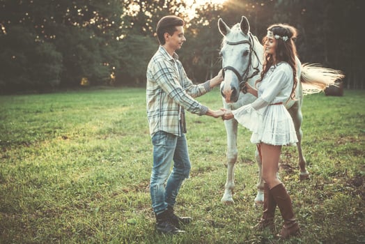Young couple taking care about beautiful horse photo