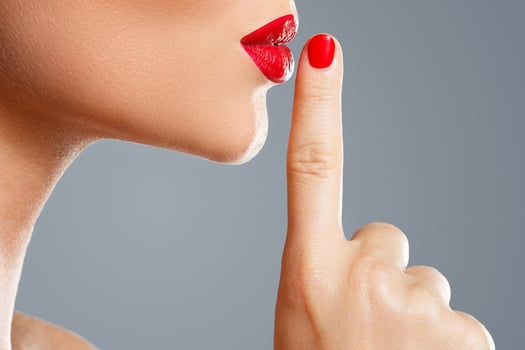 Woman is showing shush or silence gesture photo