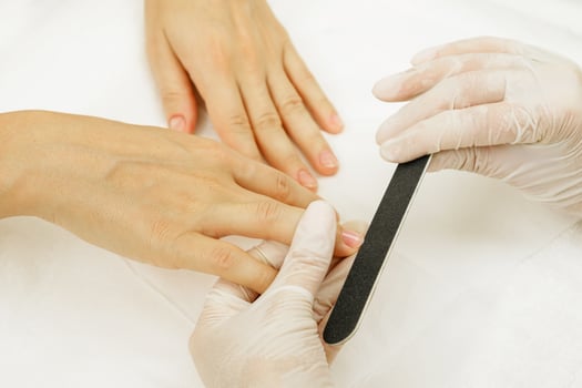 Manicure master work. Close up hands with a nail file photo