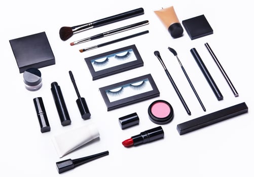 Different makeup objects and cosmetics on white photo