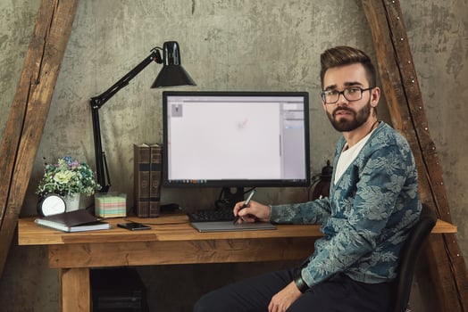 Young and handsome graphic designer working on his workplace photo