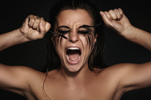 Woman with smudges of makeup on her face and broken mascara brushes photo