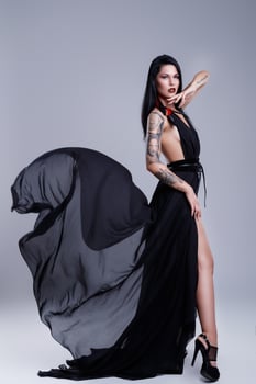 Portrait of woman with tattoos wearing black dress photo